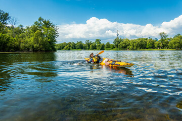 A bearded male paddler practices his bracing technique in a sea kayak  on a pond in the Toronto Islands on a warm sunny summer afternoon.  Room for text.