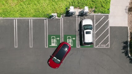 4K aerial overhead view of fully charged red electric vehicle driving away from charging station. Slow motion footage with environmental, eco-friendly, zero pollution technology concept Eco vehicle - Powered by Adobe