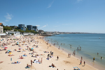Fototapeta na wymiar Estoril beach full of bathers on a clear summer day