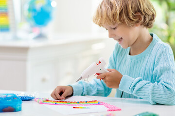 Crafts for kids. Child with hot glue gun.