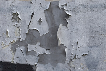Closeup of badly fixed building facade wall covered with cracks in stucco and paint.