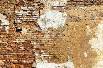 An old brick wall with various damages