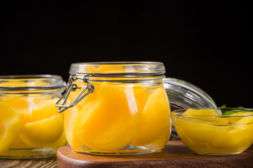 sweet canned yellow peach in glass jar on table