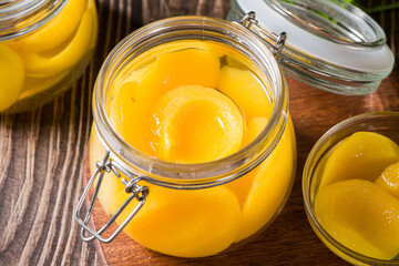 sweet canned yellow peach in glass jar on table