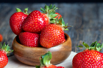 Ripe red strawberries lying on a wooden tray