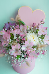 Delicate bouquet pink lilies, white roses, gypsophila. Turquoise background. Pink Heart, copy space