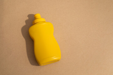 Yellow mustard typical container without label on beige background
