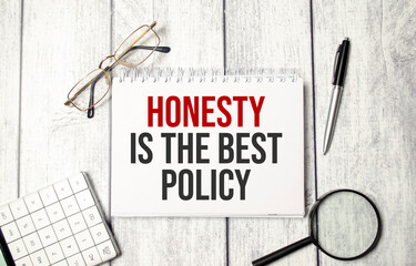 honesty is the best policy words on notepad and pen, calculator and glasses