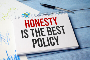 honesty is the best policy word on notepad and blue wooden background and charts