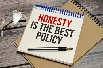 honesty is the best policy words on notepad and wooden background