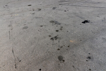 A road for vehicles covered with stains and pollution from oil and fuel of cars