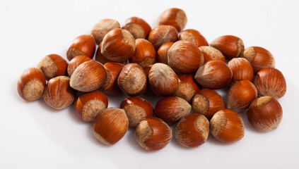 Fototapeta premium Unpeeled hazelnut on white surface closeup. High quality photo