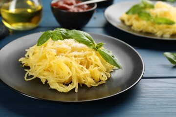 Tasty spaghetti squash with basil and cheese served on blue wooden table, closeup