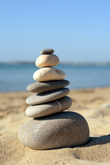 Fototapeta na wymiar Stack of stones on beautiful sandy beach