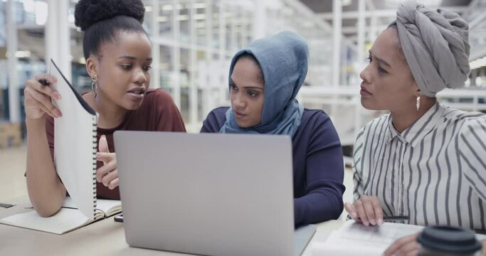 Planning, discussing and sharing ideas while diverse team of creative female entrepreneurs talk about growth and development. Multicultural businesswomen working on laptop for digital marketing task