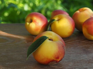 Sweet Pink Peach fruit with leaf on blur garden background, Fresh Sweet Peach on wooden basket over natural farm background