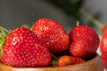 Ripe red strawberries lying on a wooden tray