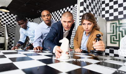 Four friends of different nationalities solving puzzles in quest room