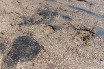 An old paved road with a lot of holes and damage
