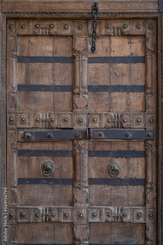 Wall mural Ancient wooden carved door decoration. Antique old Indian door with the brass door handle.