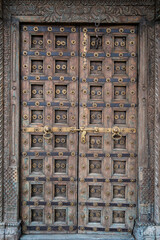Ancient wooden carved door decoration. Antique old Indian door with the brass door handle.