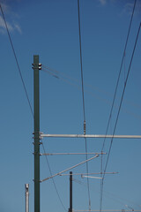 Railroad electric overhead lines under blue sky
