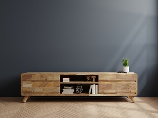 Wooden cabinet for TV in living room on dark blue wall.