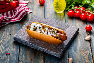 hot dog Mexican with jalapeno on board on blue wooden table