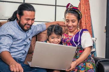family with a laptop.  An indigenous family in a rural area use technology to educate their little...