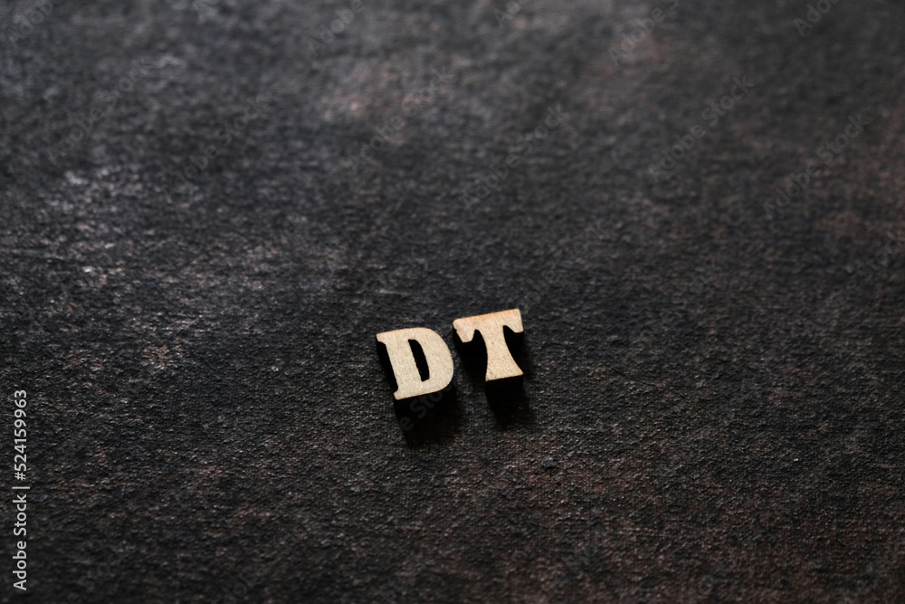 Fototapete the letters d and t above the dark field. initials dt