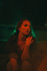 Girl with night sits on the background of red and green light