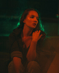 Girl with night sits on the background of red and green light