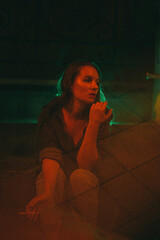 Girl with night sits on the background of red and green light