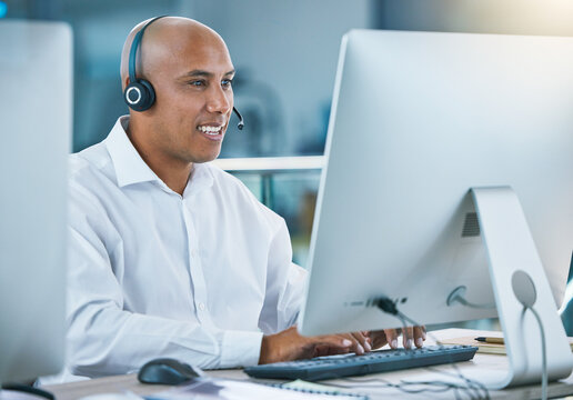 Professional, Friendly Customer Service Or Sales Consultant Agency Worker Working With Headset And Desktop. Smiling Male Employee Consulting With A Client At Call Center Or Contact Us Helpdesk