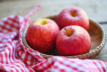 apple fruit on basket on the wooden table, ripe red apples