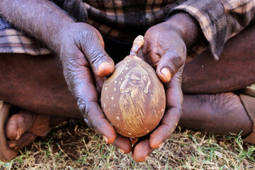 Indigenous Australian aboriginal man hands holding an engraved boab tree nut shell