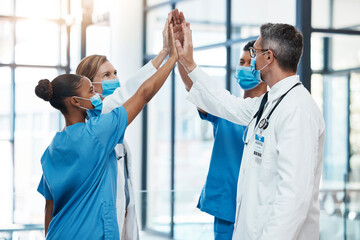 Covid doctors and nurses high five for teamwork success, collaboration and support in a hospital....