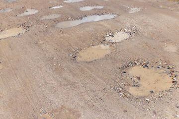 a dirt road with a lot of water holes