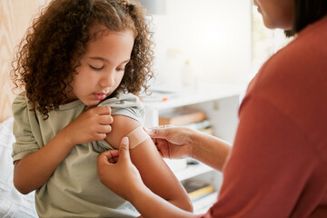 Covid nurse vaccinating child putting a bandage on at a clinic. Doctor applying plaster on girl after an injection at health centre. Pediatric, immunity and prevention at medical childrens hospital