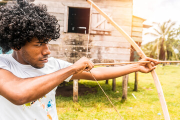 Afro-descendant latin teenager on the north caribbean coast of nicaragua taking aim with a bow and arrow