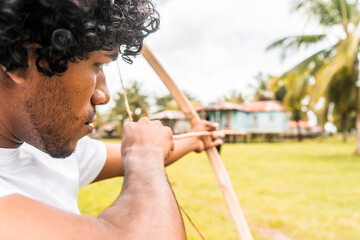 Afro-descendant latin teenager on the north caribbean coast of nicaragua taking aim with a bow and...
