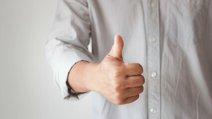 Businessman showing OK approve or like signal with thumb raise up. Successful concept. Business man shows thumb up sign gesture. Businessman showing thumbs up - closeup shot.