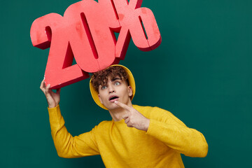 a surprised, shocked man stands on a green background in bright clothes and with his mouth wide...