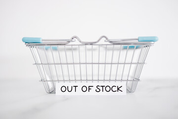 out of stock text in front of empty shopping basket on white background, supply chain shortages and...