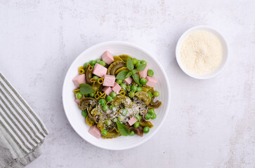 Green pasta with peas, sausages and cheese