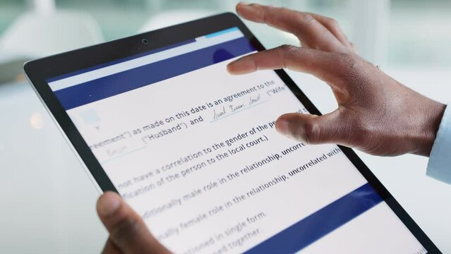 Divorce lawyer analyzing online contract with hands on tablet filling in settlement agreement legal document or file closeup. African man zooming in marriage form from attorney for cheating affair