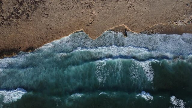 Waves hitting beach, top down drone view of relaxing ocean coast background