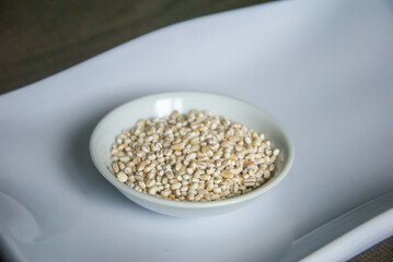 Bowl of organic pearl barley on white plate