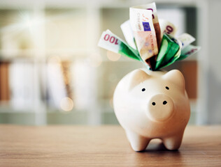 . Banking, finance and paper money in piggybank for future savings, budget and profit on a table for wealth. Closeup of a tool to save European cash notes, investment and financial growth on a desk. © Lumeez Ismail/peopleimages.com
