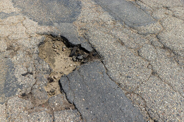 An old paved road with a lot of holes and damage